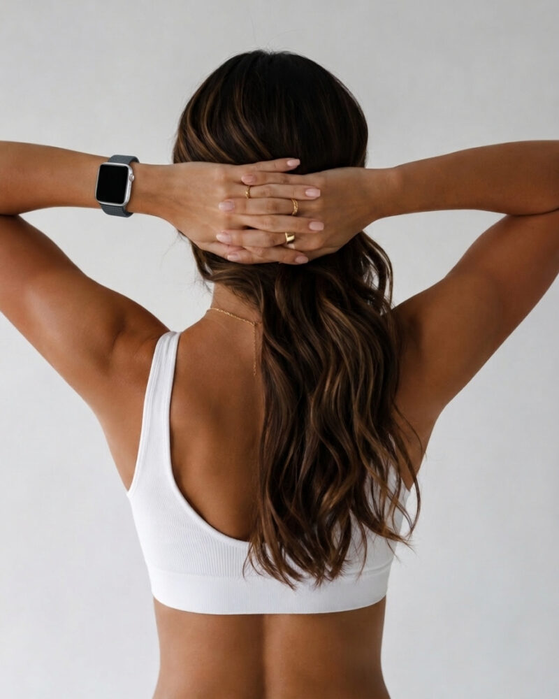 Woman wearing Storm Grey Sport Loop smartwatch band on white background