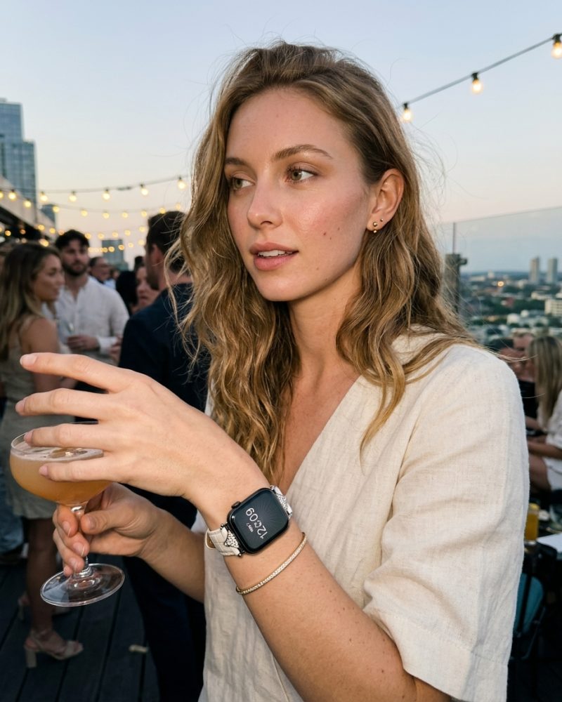 Woman wearing cappuccino leather strap smartwatch at rooftop event