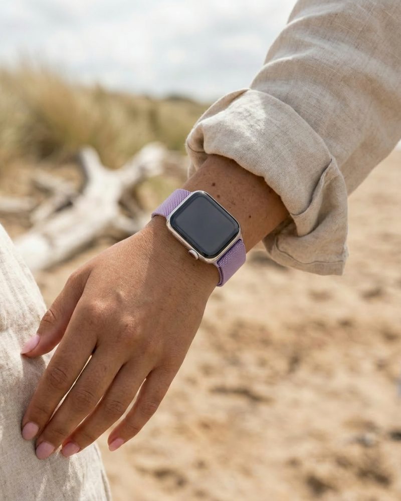 Woman wearing lavender Milanese loop smartwatch band at beach outdoors