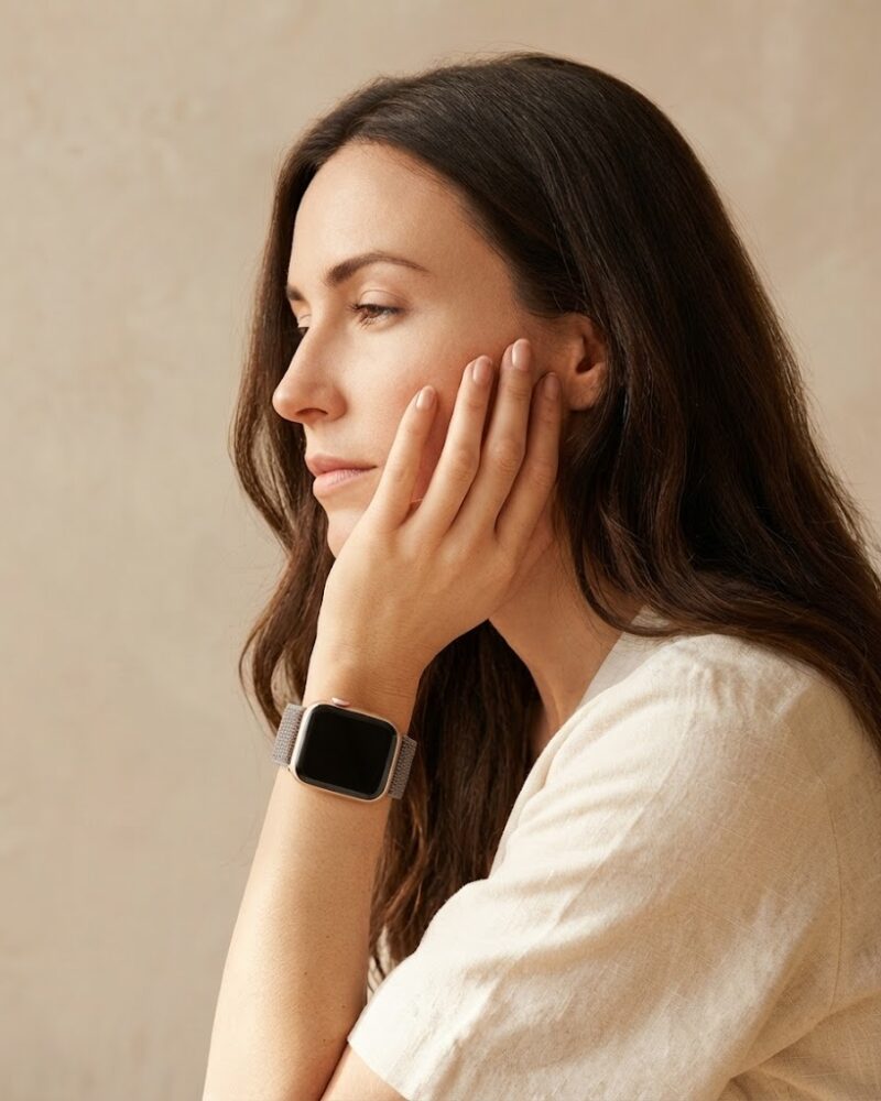 Woman wearing pink sand sport loop smartwatch on wrist, side profile