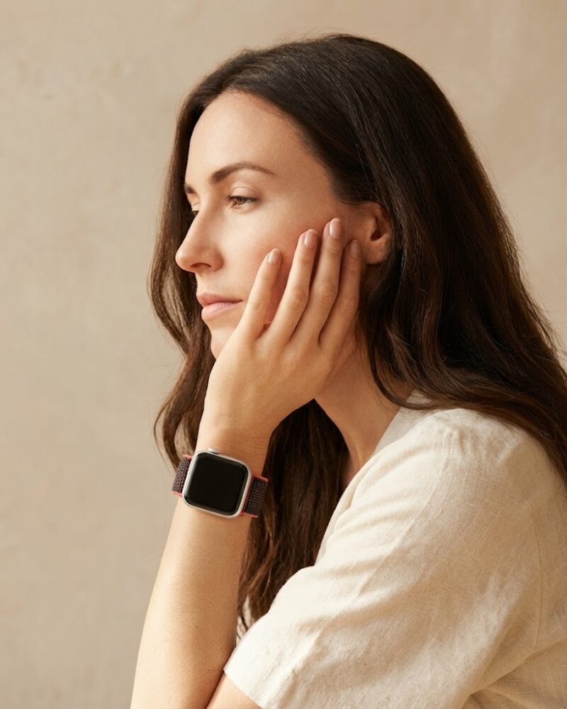 Woman wearing red and black sport loop smartwatch band on wrist