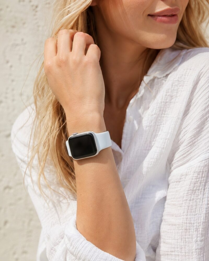 Woman wearing white shirt with sky blue sport band smartwatch on wrist