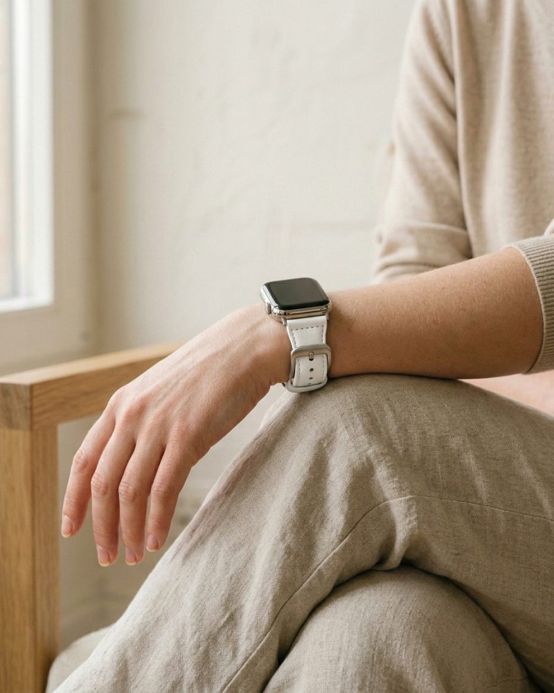 Woman wearing Apple Watch with white leather strap band