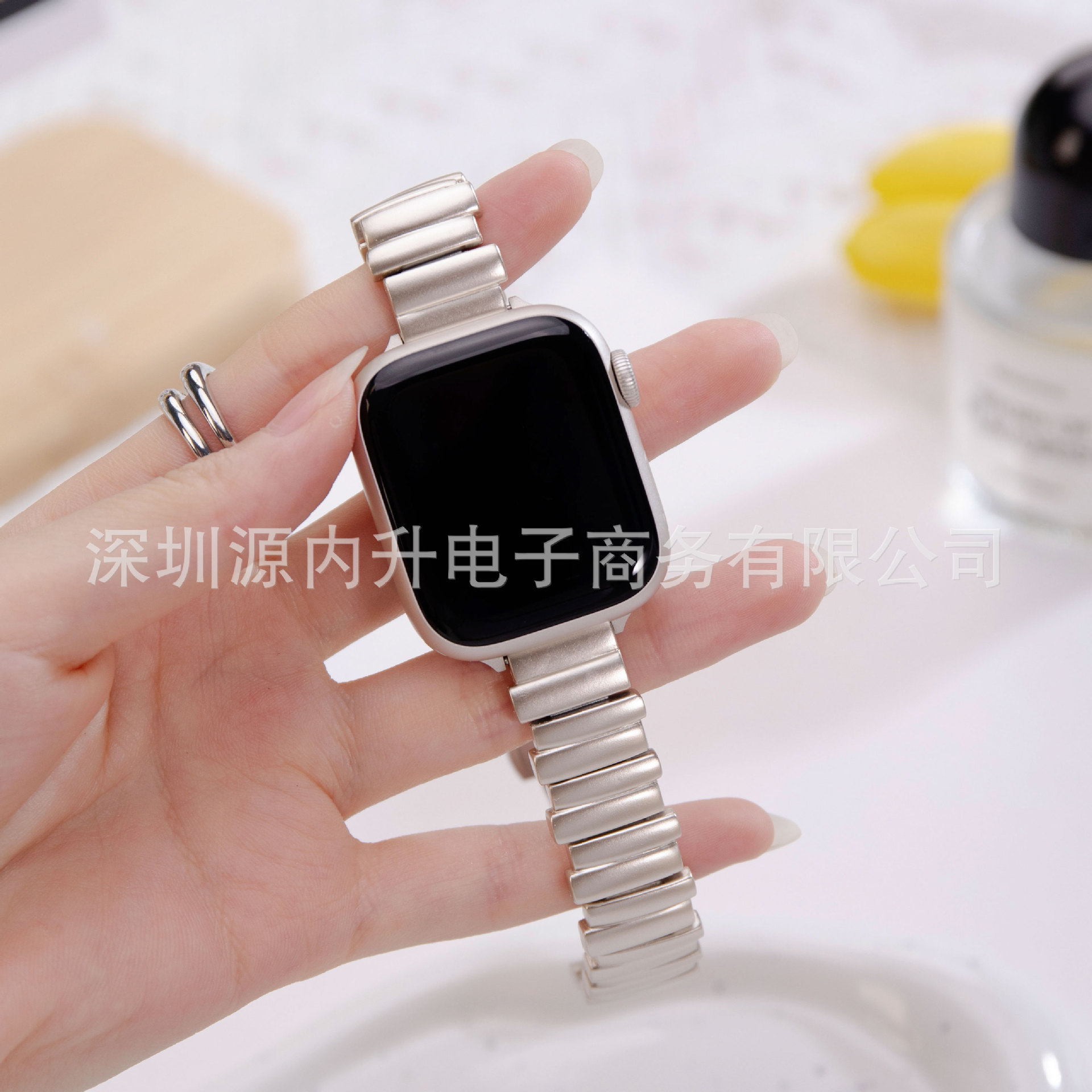Silver metal strap smartwatch with black square display on hand