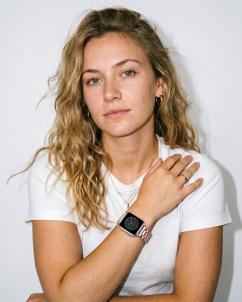 Rose gold steel strap smartwatch band worn on woman's wrist