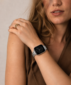 Silver stainless steel smartwatch band on woman's wrist with ring