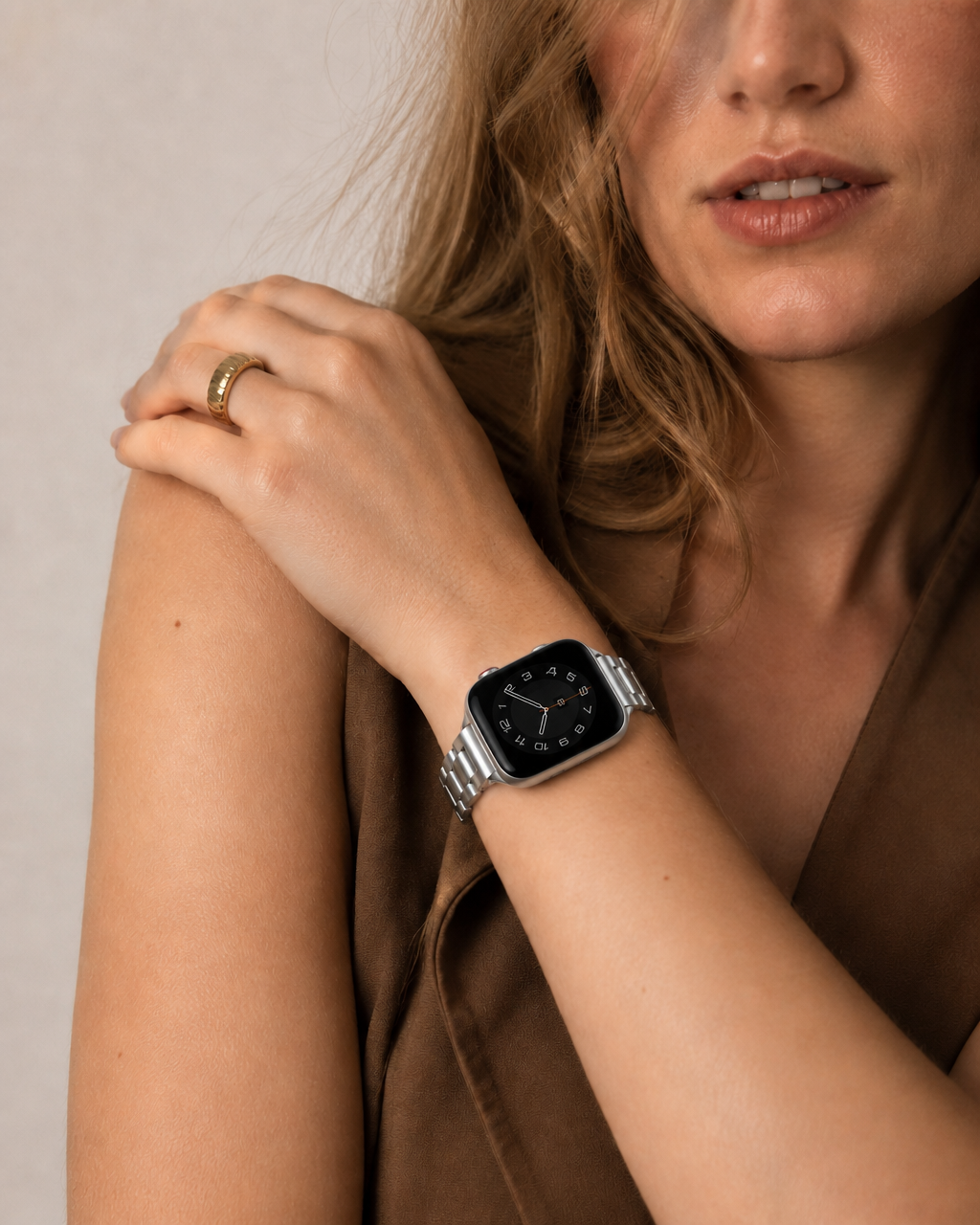 Silver stainless steel smartwatch band on woman's wrist with ring