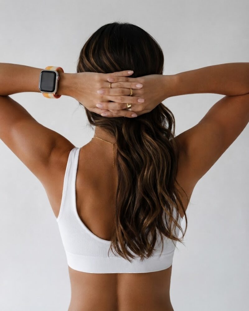 Woman wearing white sports bra with maize sport loop smartwatch band