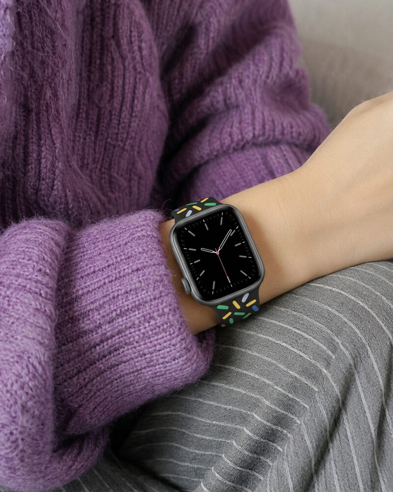 Smartwatch with black face and colorful pride sport band on wrist