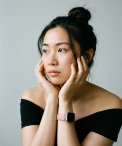 Pink leather Apple Watch band on woman's wrist, cherry blossom color