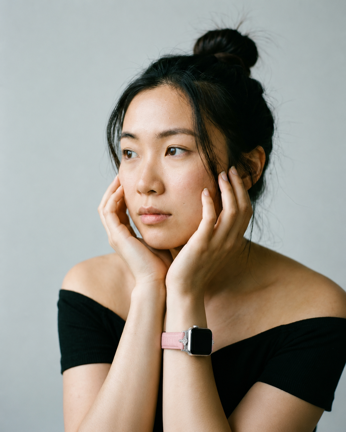 Pink leather Apple Watch band on woman's wrist, cherry blossom color