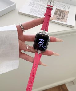 Crimson leather smartwatch band with diamond-studded metal connector on wrist
