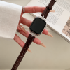 Apple Watch with dark brown leather strap and crystal bezel design