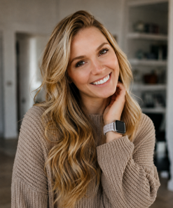 Woman wearing beige knit sweater with white leather Apple Watch band
