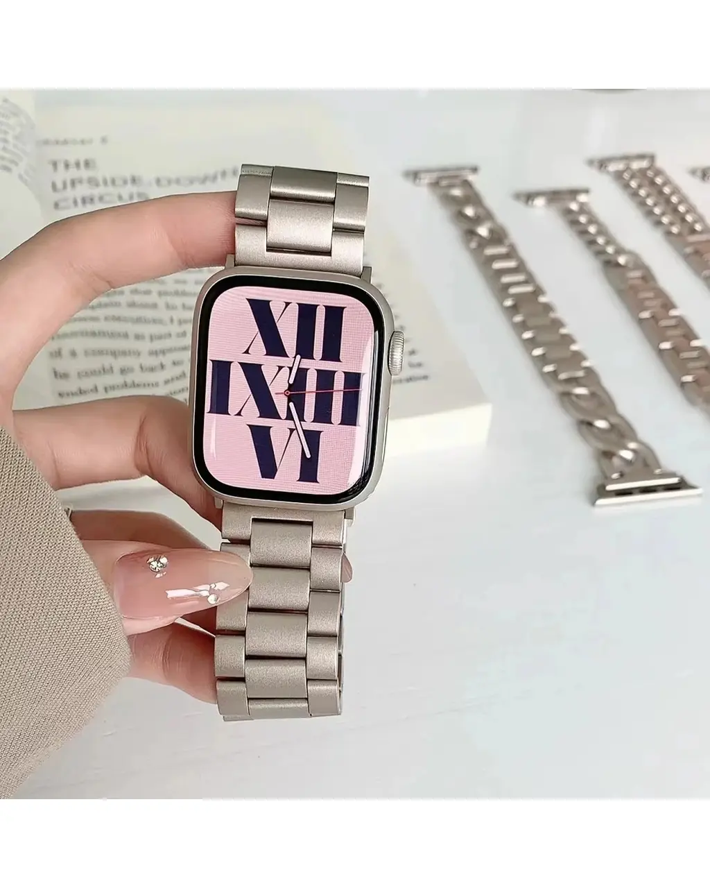 Stainless steel smartwatch with pink dial and Roman numeral display