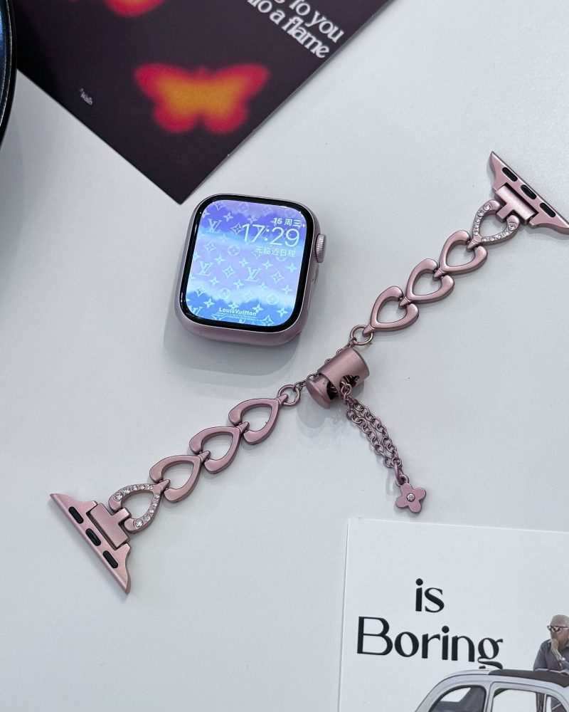 Rose gold heart-shaped smartwatch band with rhinestone accents and charm
