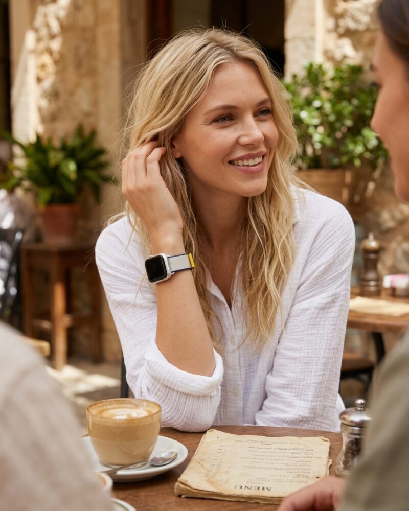 Woman wearing sea salt sport loop smartwatch at outdoor café table